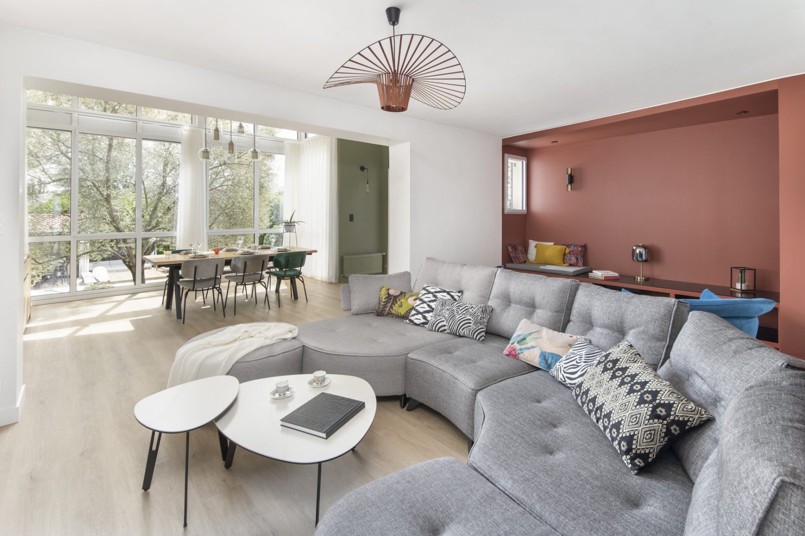 Séjour ouvert sur jardin avec baie vitrée, canapé modulable et coin repas – Koloré architecte d'intérieur L'union